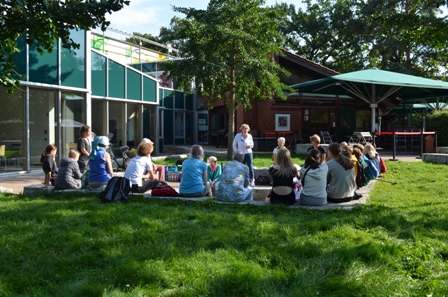 Viele Menschen sitzen bei sonnigem Wetter im Garten der Menschenrechte zusammen, um etwas über ihn zu erfahren