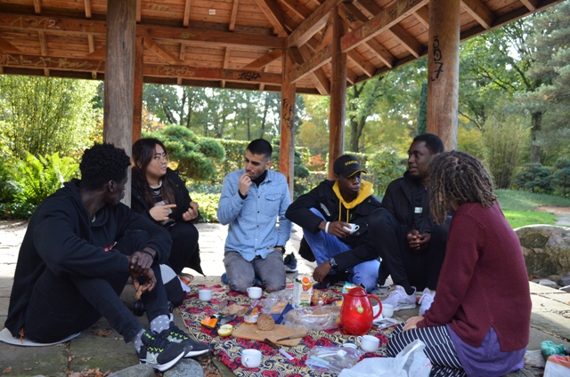 Gruppe junger Erwachsener des PULSCAMP essen und unterhalten sich im Rhododendronpark