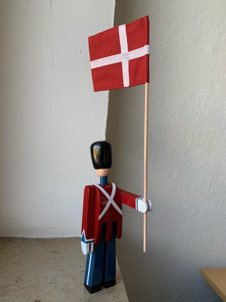 Kleine Holzfigur mit dänischer Flagge in der Hand